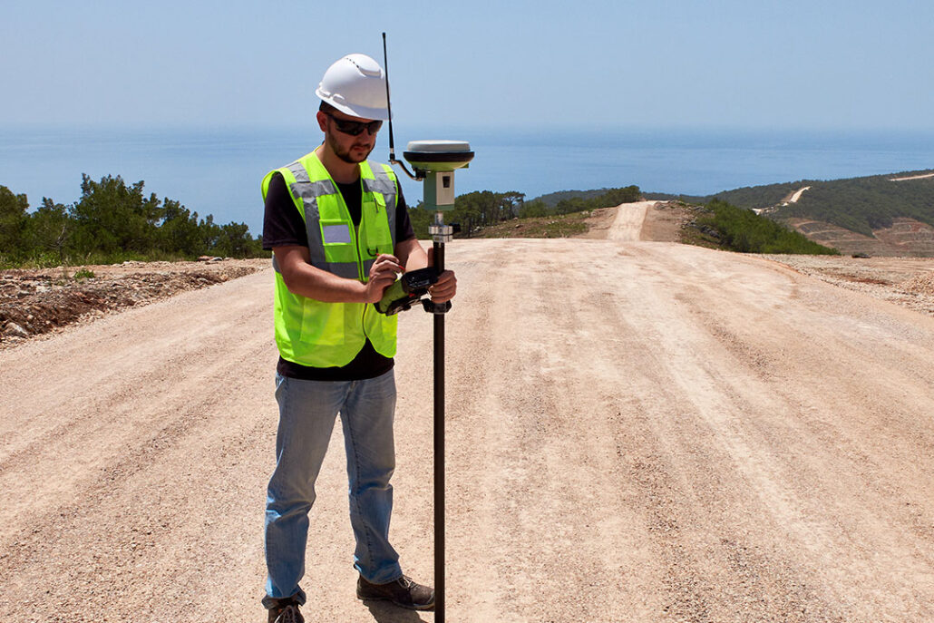 civil engineer surveying road with handheld gps