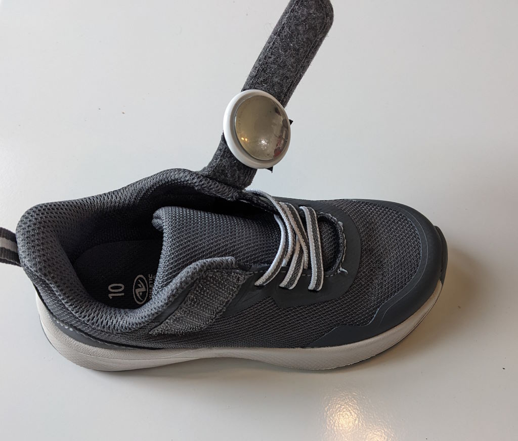 apple airtag with velcro attached and hidden in kids shoe