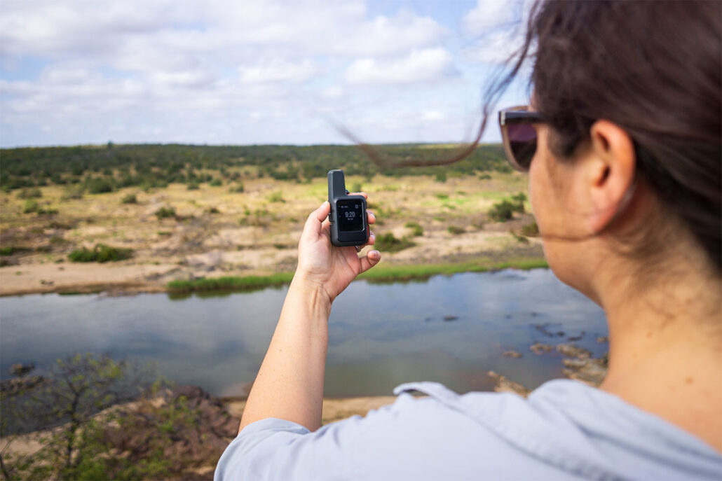 woman using a personal locator beacon in the wilderness