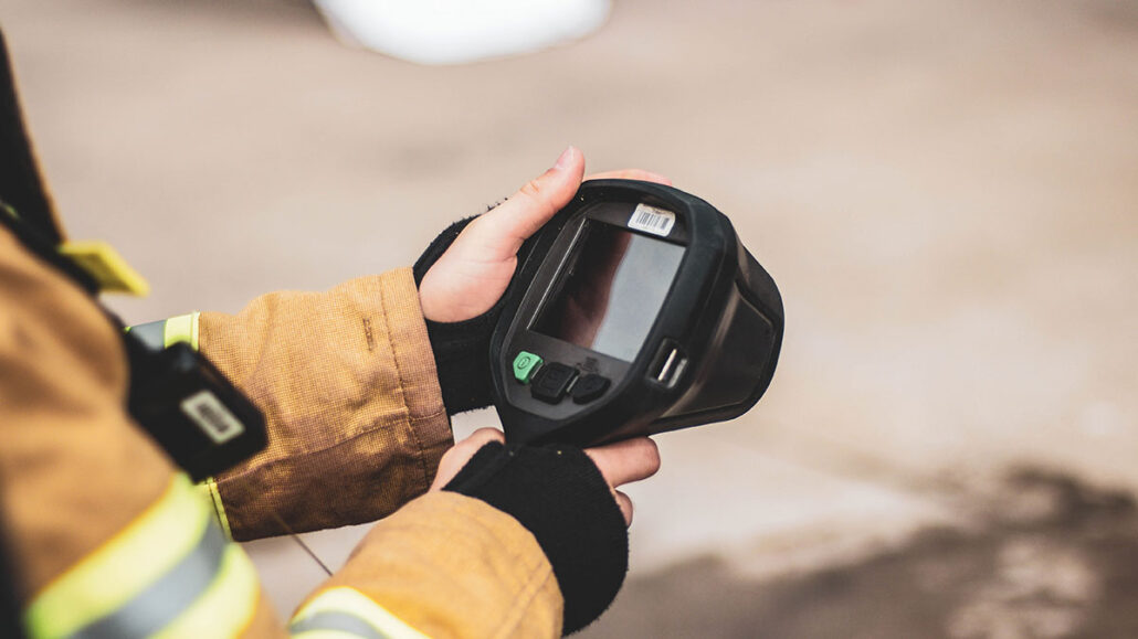 firefighter holding thermal imaging camera